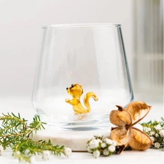 Close-up on a cocktail glass with three tiny ducks swimming in the